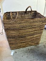 Full view of oversized wicker basket in natural brown colors, showing shape and weave texture.