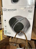 Photo of the front of the box showing Shiatsu Foot Massager with features like switchable heat, air pressure, and kneading.