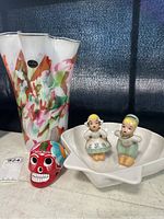 Shows the entire lot including the marbled vase, ceramic shell server with figurines, and the painted skull.