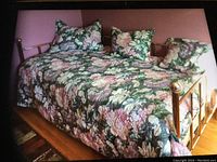 Photo of floral covered brass day bed with pillows, showing overall condition and frame.