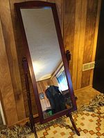 Full-length mirror showing mahogany wood frame, swivel stand with turned wood columns, leaning slightly back at an angle.