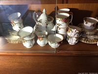 Collection of tea cups, saucers, teapot, sugar bowl and creamer displayed together