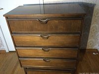 Front view of tall boy walnut veneer chest of drawers with four dovetailed drawers and recessed handles