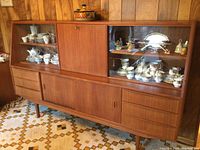 Front view of teak credenza showing glass display cabinets, drawers and sliding doors