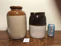 Front view showing two crocks side by side next to a soda can for scale on wooden surface