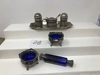 Tray with lattice-pattern salt and pepper shakers and mustard pot, cobalt blue glass liners visible