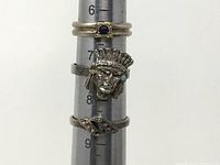 Three rings stacked on ring sizing mandrel showing sizes and design details for the lot