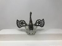 Front view showing the swan with wings spread open revealing the glass dish body underneath