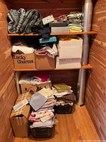 Photo of wooden shelves with folded fabric piles and boxes with fabric inside