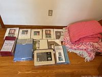 Overview of all curtain panels packed and stacked alongside folded throw blankets.