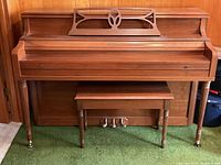 Full front view of the Mason & Risch upright piano with bench placed underneath, highlighting wooden construction and brass pedals.