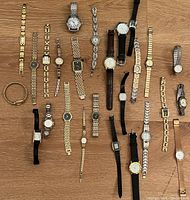 Overview of 22 watches arranged on wooden surface