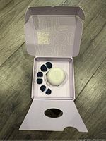 Open box showing Loop Quiet earplugs, white carry case, and multiple black silicone ear tips arranged around the case