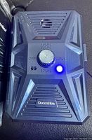 Black Queen Mew ultrasonic dog bark deterrent device showing frequency control knob and blue power LED.