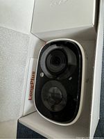 Smart wireless battery camera inside branded LongPlus box, showing camera front with lens and sensors.