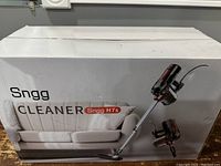 Box front showing Snagg H7s vacuum cleaner in use on a couch and floor.
