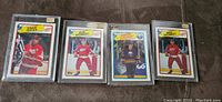 Photo showing four 1988-89 hockey cards in individual hard plastic cases: Adam Oates (O-Pee-Chee), Bob Probert (O-Pee-Chee), Pierre Turgeon (O-Pee-Chee), and Bob Probert (Topps). Cards are in mint condition as per seller.
