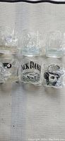 Photo showing 6 heavy 9 oz rocks glasses with Jack Daniels and Philadelphia Flyers logos on them. Glass design and logos clearly visible.