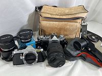 All lot items arranged: two camera bodies, lens, spotmeter, two teleconverters, bag
