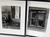 Photo showing two framed black and white prints side by side. One depicts a vintage interior mining communication room with a listed mine bell signals chart. The other shows a close-up of a broken window with peeling paint on the wooden frame.