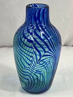 Front angle view of blue swirl art glass vase, showing shape and pattern