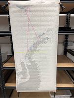 Full vertical view of the Antarctic Peninsula map rolled and hanging with clamps on a shelf