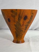 Front view of the smooth conical shaped bowl showing the natural grain patterns and knots in Norfolk Island Pine wood.