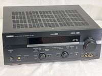 Front view of Yamaha RX-V657 AV Receiver showing control knobs, display, and input ports.