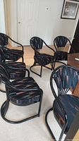 Group of six metal frame chairs with cushioned seats and backs in a dark patterned fabric.
