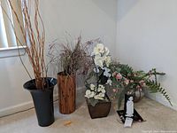 Wide shot of five faux floral and decor items in various vases including Asian style and modern designs on carpet near window.