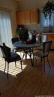 Full view of round kitchen table with metal base and 4 metal frame chairs with fabric upholstered seats in a kitchen setting
