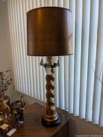 Full view of the large table lamp with twisted gold base and metal-look brownish lampshade