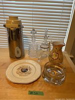 Photo showing the full collection of vintage vessels including stainless steel hot beverage dispenser, two clear glass decanters, ceramic jug, glass ashtray, and serving platter