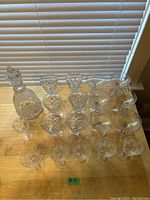 Top-down view of entire set laid out on wooden surface showing decanter and all glasses.