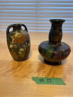 Pair of small Dutch Art Nouveau Amphora matte pottery vases, one with two handles and chrysanthemum decoration, the other a bulbous vase with floral and leaf motifs.