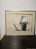 Full-frontal view of framed sketch showing charcoal/graphite artwork, misaligned matte, simple metallic frame.