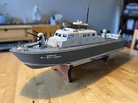 Side view of the wooden model war ship on its stand, showing the USAF markings and front guns.