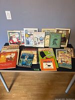 Wide view of 15 vintage children's books laid out on a table featuring various titles and authors from the mid to late 20th century.