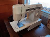 Side view of the Singer Merritt 2502C sewing machine showing overall structure and basic condition.