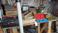 Wide view of various tools and items including wooden boxes, flower pots, red soldering iron kit case, shop light, and the mitre box with orange clamp.