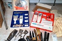 Overview of vintage barber kits in original boxes along with several grooming tools arranged on the floor.