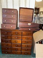 Three wooden storage units stacked: multi-drawer cabinet at bottom, four-drawer cabinet and jewelry box on top