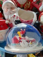 Close-up of ceramic Santa Claus planter with missing top opening and some paint wear.