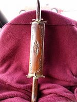 Full view of a wooden carving set with metal fittings against a red background.