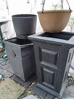 Four planters grouped on patio, showing variety and condition including metal planter with crushed corner