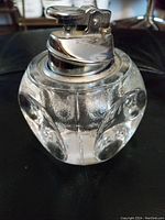 Close-up of the front of the vintage Ronson crystal gas lighter showing the textured crystal glass body and chrome metal lighter top.