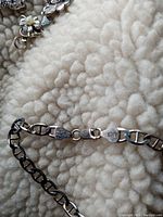 Close-up image of the silver bracelet chain and lobster clasp showing the "Italy" and "925" markings stamped on the clasp tags.