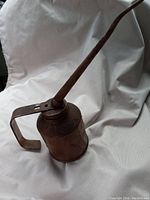 Side angle view of vintage Goldenrod oil can showing cylindrical body, spout, and handle