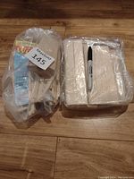 Two separate plastic bags containing balsa wood pieces for crafting, placed on wooden surface with a black Sharpie marker for scale.