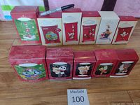 Ten Hallmark Keepsake Christmas ornaments in original boxes arranged in two rows on a wooden surface. Includes a Sharpie marker for scale.